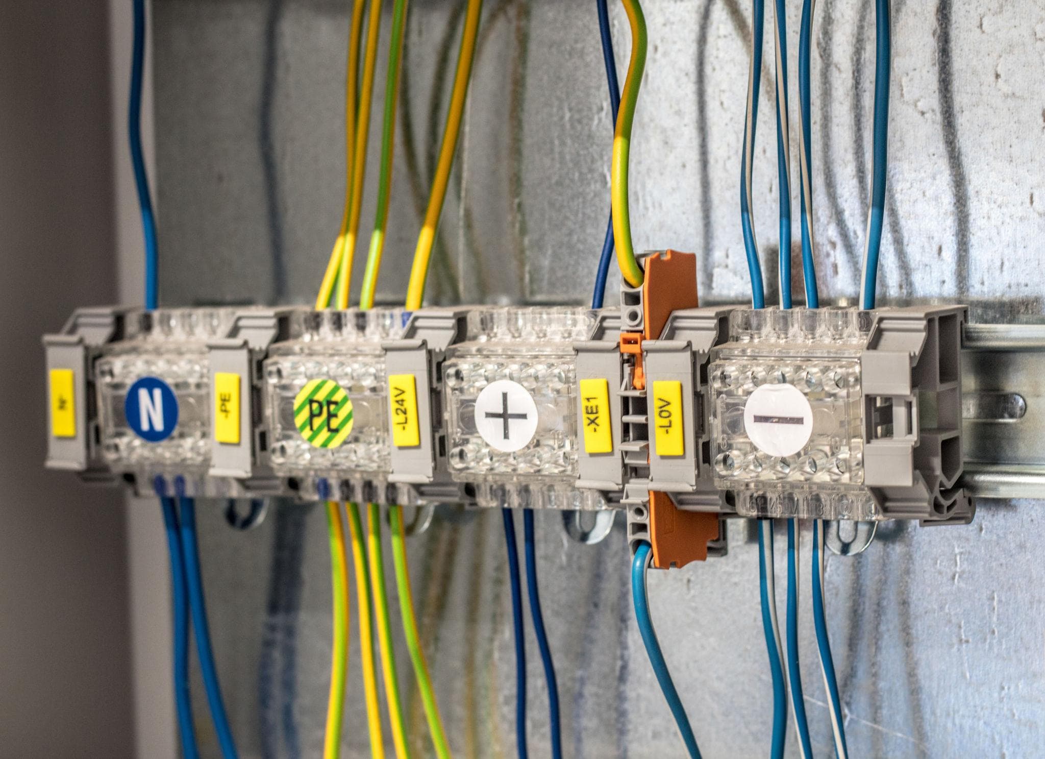 Transparent terminal blocks and blue-yellow wiring in an electrical panel